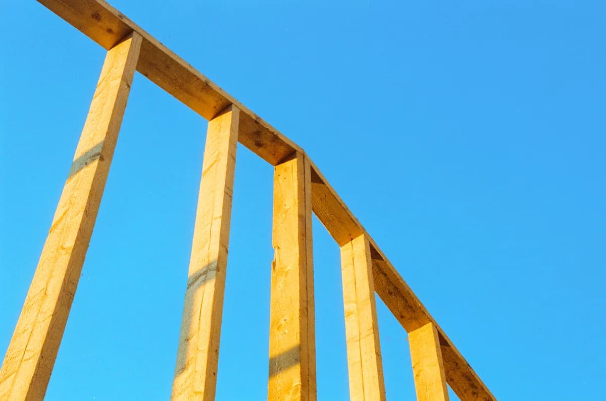 A framer working on the wall of a timber-framed building